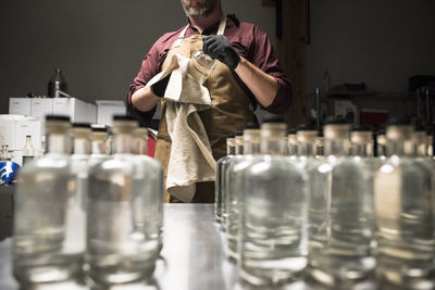 A distiller cleaning of fresh bottles of liquor.