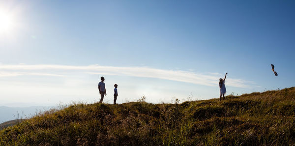 People standing on land against sky