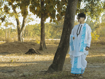 Man standing by tree on field