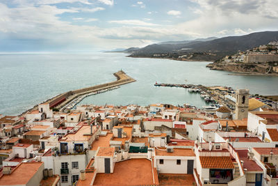 High angle view of townscape by sea against sky