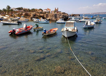 High angle view of sailboats moored on sea against sky