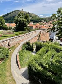 Road by canal amidst buildings against sky