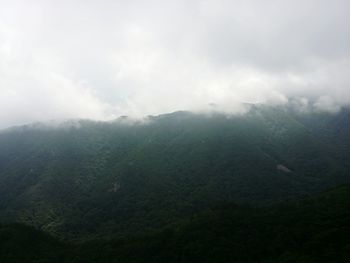 Scenic view of mountains against cloudy sky