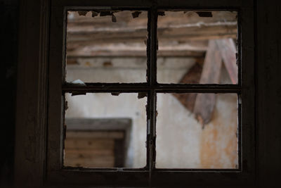 Close-up of old broken window in abandoned building