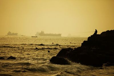 Rocks in sea at sunset