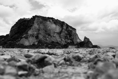 Rock formations on beach against sky