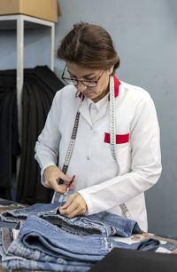 Woman worker in textile factory checking the quality of the garments. industrial production