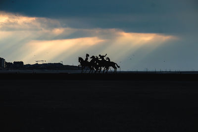 Silhouette horse on field against sky during sunset