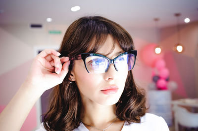 Close-up of young woman wearing eyeglasses at home