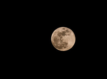 Low angle view of full moon against sky at night