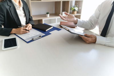 Midsection of man using laptop on table