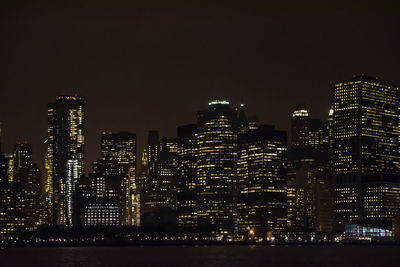 Illuminated buildings in city against sky at night