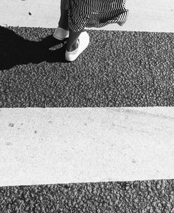 Low section of woman standing on road