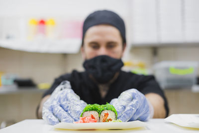 Portrait of man with ice cream in plate on table