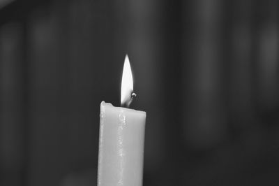 Close-up of lit candle in dark room