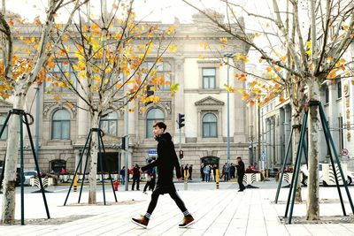 Full length of man walking on street against buildings