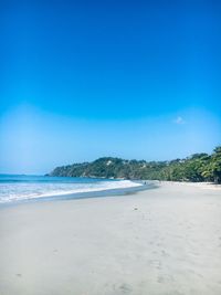 Scenic view of beach against clear blue sky