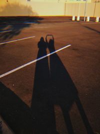 Shadow of man and woman on road