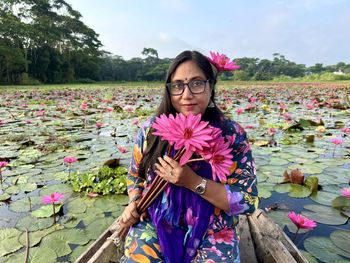 Portrait of a woman sitting on a boat on marshy waters .