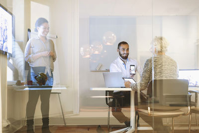 Happy businesspeople using technologies in office