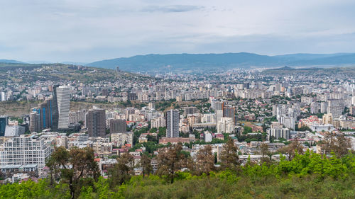 Aerial view of buildings in city against sky