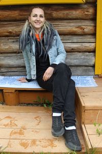 The girl is sitting on a pile of rubble