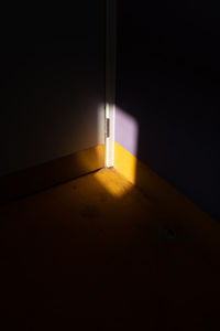 Illuminated lamp on wall at night