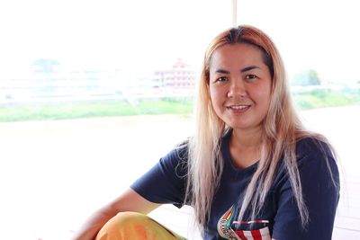 Portrait of smiling woman sitting outdoors