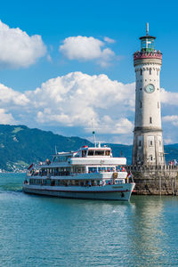 Lighthouse by sea against sky