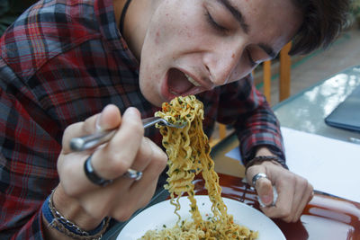 Man eating noodles at restaurant