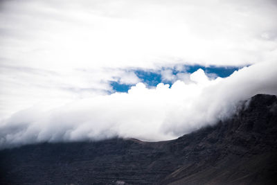 Scenic view of mountains against cloudy sky