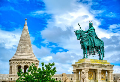 Low angle view of statue of building against cloudy sky