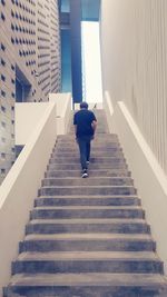 Rear view of boy walking upstairs