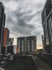 Road by buildings against sky in city