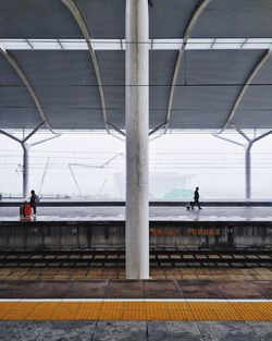 Rear view of people waiting on railroad station platform