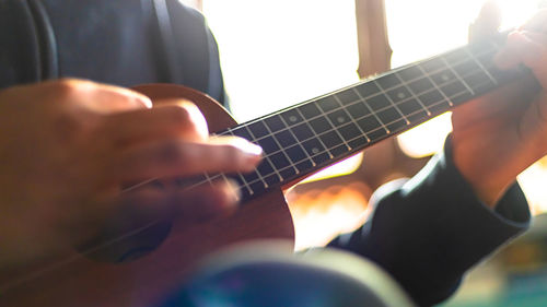 Midsection of man playing guitar