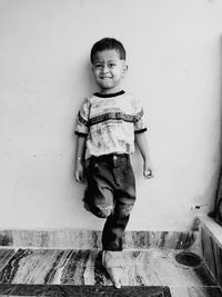 Portrait of smiling boy against wall