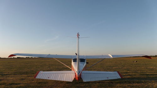 Airplane on airport runway against sky