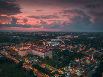 High angle view of illuminated buildings in town against sky during sunset