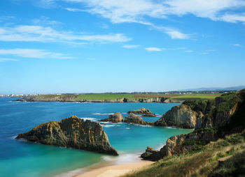 Scenic view of sea and cliff against sky