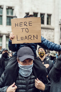 People holding text on street in city