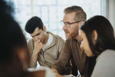 Mature professor explaining students in classroom at university