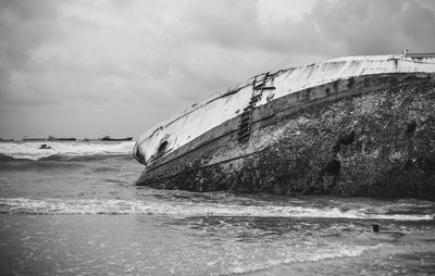 Shipwreck in sea against sky