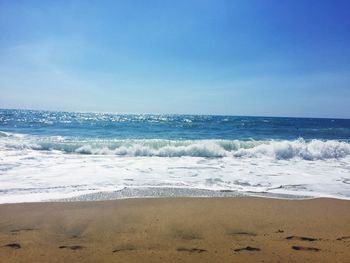 Scenic view of beach against blue sky