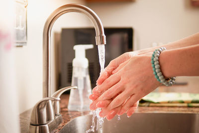 Cropped image of woman washing hands