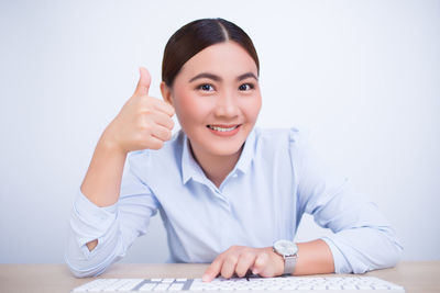 Portrait of a smiling young woman sitting on table