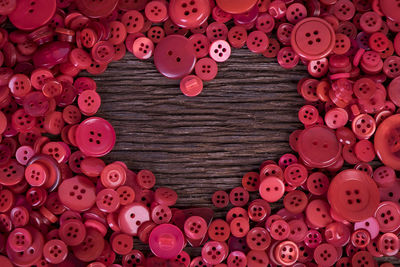 Full frame shot of buttons arranged in heart shape on table 