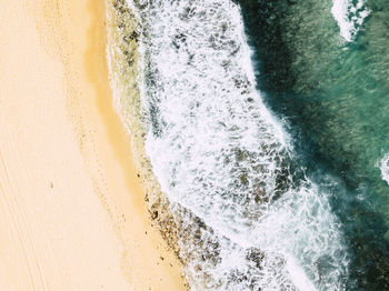 High angle view of waves rushing towards shore