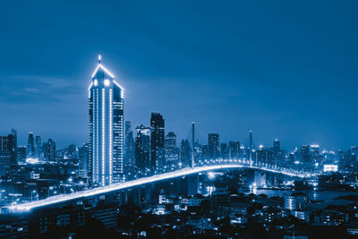 Illuminated cityscape against sky at night