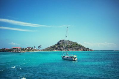 Boats in sea against blue sky